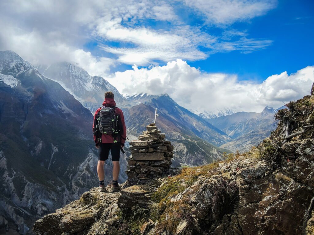 Traveller standing on the cliff watching Himalayas - BonVoyah Travel Guide